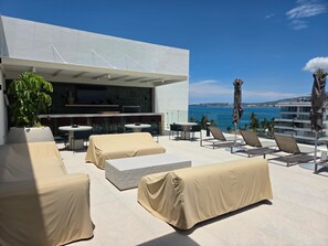 A rooftop terrace with outdoor seating, a bar area, and a view of the ocean. - Vrbo Property (Bucerías)