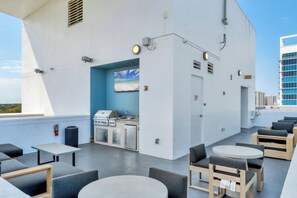 A rooftop bar with outdoor seating, a grill, and a view of the city. - Contemporary 2BR/2BA in downtown Orlando (Orlando)