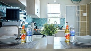 Une cuisine avec un plan de travail, une plante en pot et des ustensiles de cuisine.