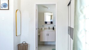 Une salle de bain avec un lavabo, un miroir et des placards.