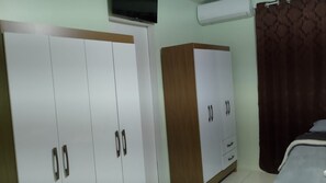 A bedroom with a bed, a wardrobe, and a television. - Hotel da Luz (Pinhão)