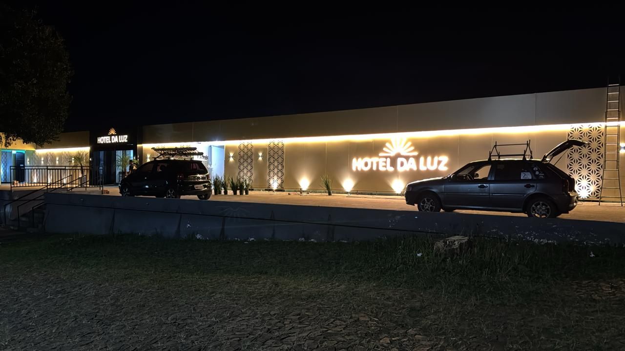 Ein Hotel Eingang mit einem Schild, auf dem 'HOTEL DA LUZ' steht, und zwei Autos davor geparkt.