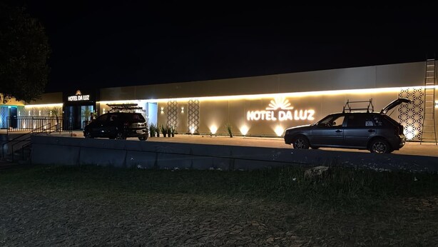 A hotel entrance with a sign reading 'HOTEL DA LUZ' and two cars parked in front. - Hotel da Luz (Pinhão)