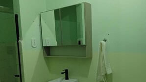 A bathroom with a white sink, a mirror above it, and a towel hanging on a hook. - Hotel da Luz (Pinhão)