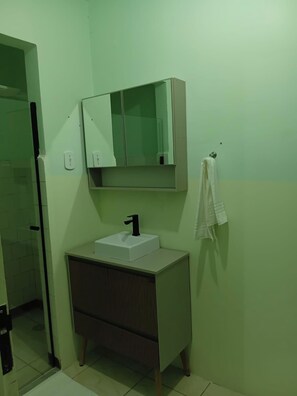 A bathroom with a white sink, a mirror above it, and a towel hanging on a hook. - Hotel da Luz (Pinhão)