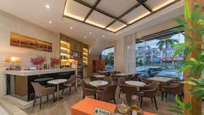 Eine Hotelhalle mit einer Rezeption, einer Sitzecke und Blick auf die Straße.