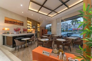 Eine Hotelhalle mit einer Rezeption, einer Sitzecke und Blick auf die Straße.