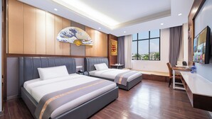 Ein Hotelzimmer mit zwei Betten, einem Schreibtisch, einem Stuhl, einem großen Fenster und einem traditionellen japanischen Fächer.