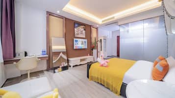 A hotel room with a bed, a desk, a chair, and a large mirror.
