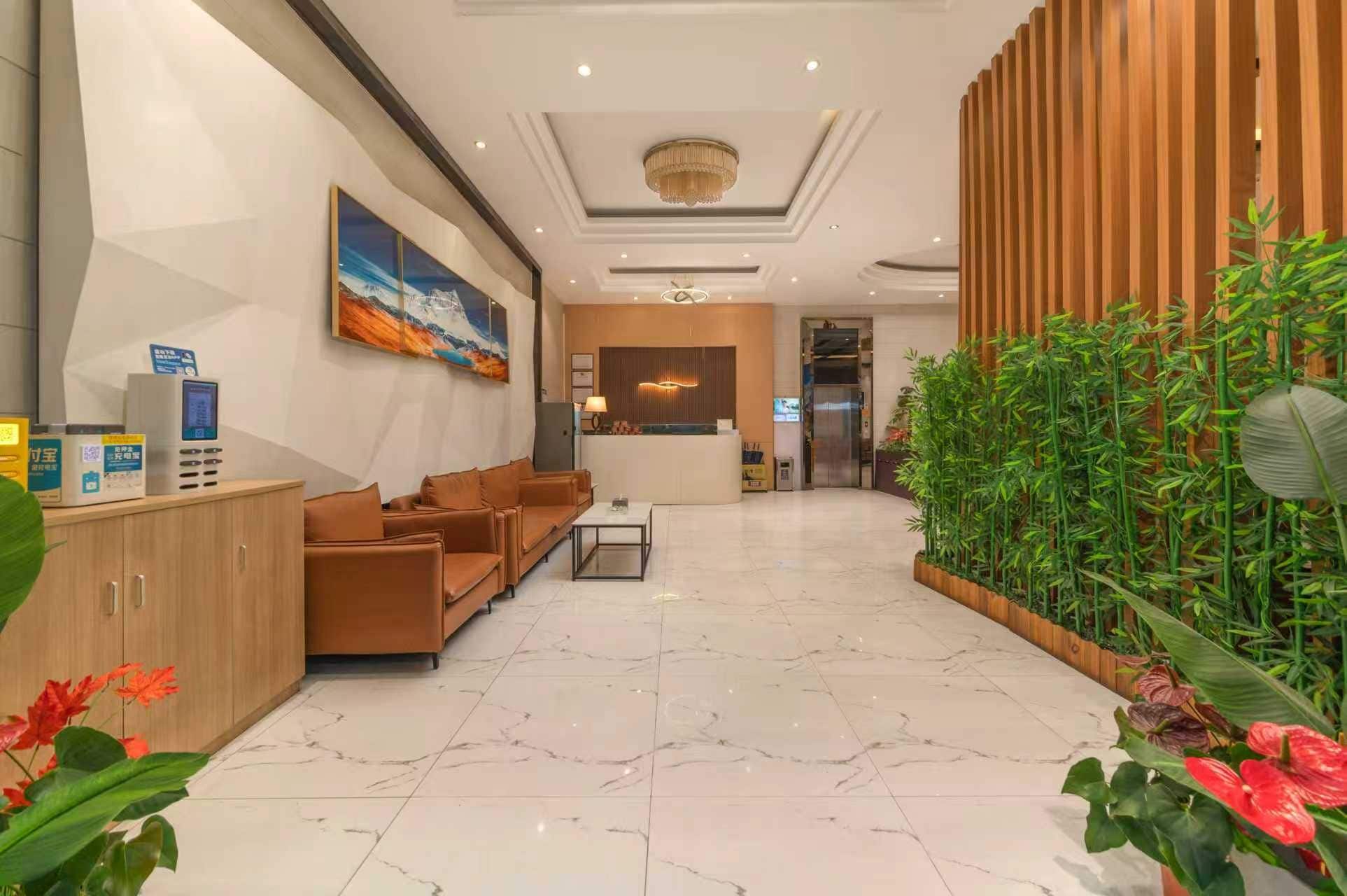 Un vestíbulo de hotel con mostrador de recepción, zona de estar y jardín vertical.