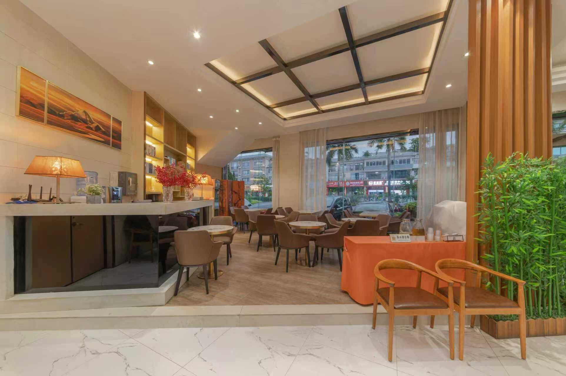 Un moderno vestíbulo de hotel con mostrador de recepción, zona de estar y grandes ventanales con vistas a la ciudad.