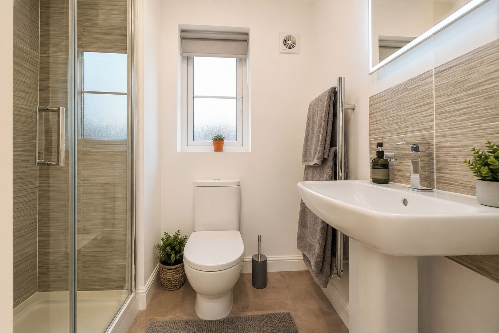 Un bagno con cabina doccia in vetro, un WC, un lavandino con specchio e una finestra con una pianta.