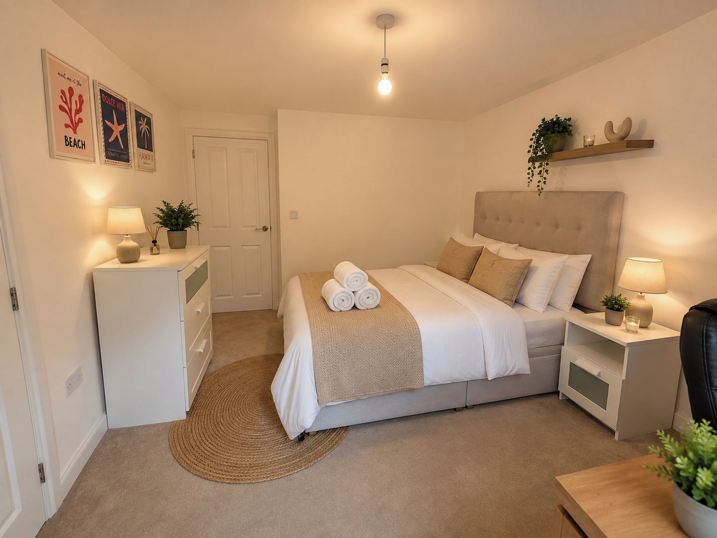 Une chambre bien rangée, avec un lit, des tables de chevet, un petit bureau et une porte.