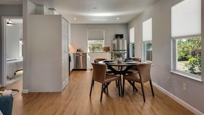A modern kitchen with a dining area, large windows, and a view of the outdoors. - Theater, Spa, Gym, & Vinyls: 2 Homes, 1 Epic Stay! (Austin)