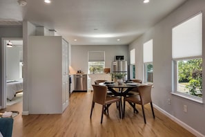A modern kitchen with a dining area, large windows, and a view of the outdoors. - Theater, Spa, Gym, & Vinyls: 2 Homes, 1 Epic Stay! (Austin)