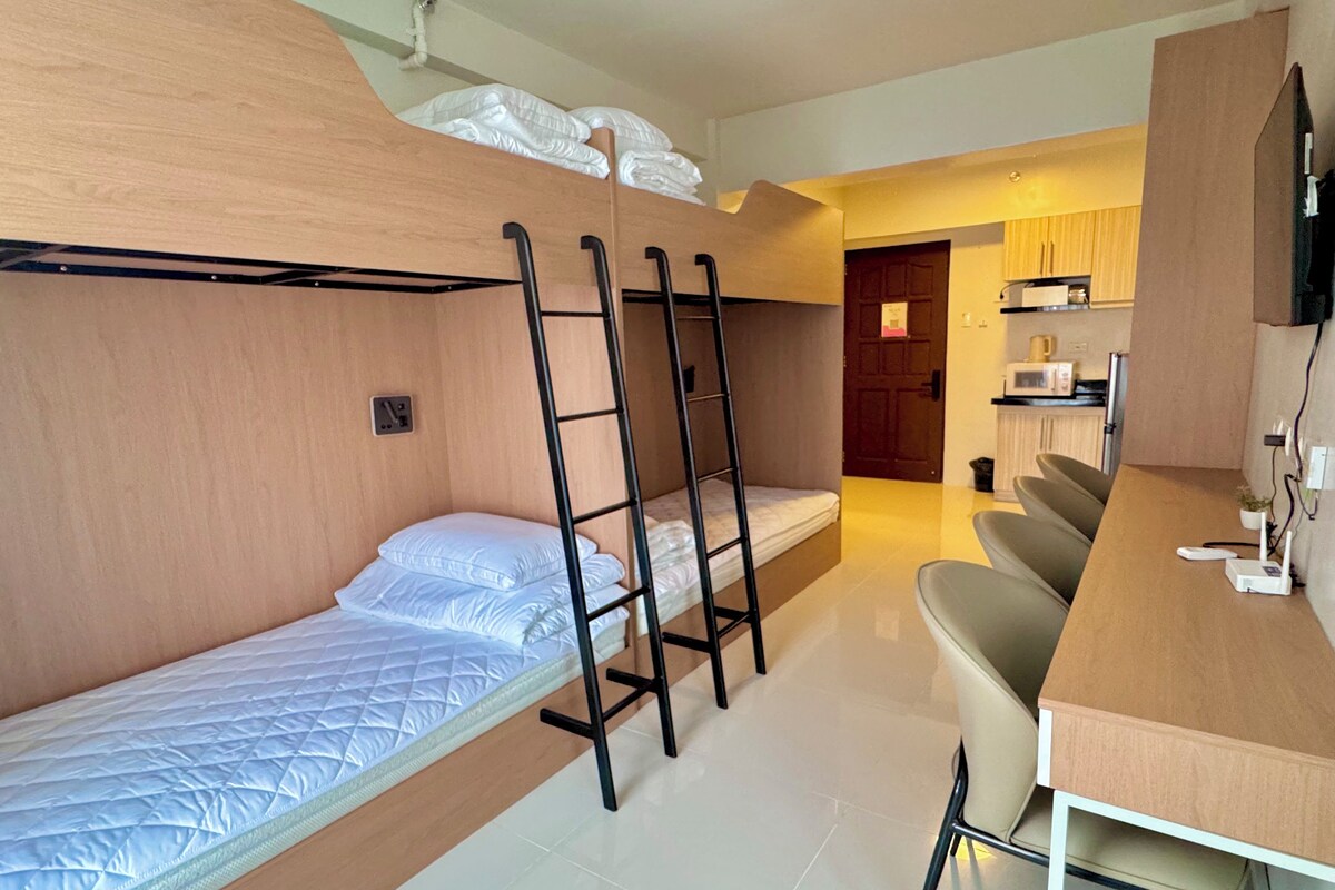 Quarto compacto com beliches, escrivaninha e cozinha compacta.