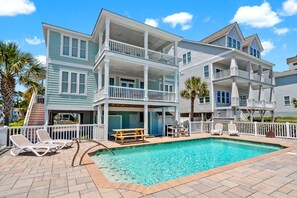 A multi-story hotel with a swimming pool, outdoor seating, and a balcony. - Modern Oceanfront 5BR Home, Private Pool, Elevator, Sleeps 18, Ocean Drive Location (North Myrtle Beach)