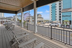 A covered outdoor area with wooden benches, a view of the street, and a building labeled 'Shalimar 2908'. - Tides & Vibes: Spacious 5BR Retreat w/ Private Pool, across the street from the beach (North Myrtle Beach)