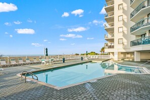A swimming pool with lounge chairs and a view of the ocean. - Oceanfront 4BR condo with stunning views, pools, lazy river, and prime location near Main Street! (North Myrtle Beach)