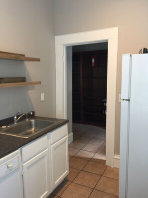 Eine Küche mit Spüle, Schränken und einem Kühlschrank.