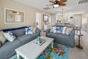 A living room with two grey sofas, a white coffee table, and a colorful rug. - Waterfront channel home close to beach - fishing and crabbing (North Myrtle Beach)