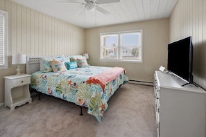 A bedroom with a bed, nightstands, a television, and a ceiling fan. - Waterfront channel home close to beach - fishing and crabbing (North Myrtle Beach)