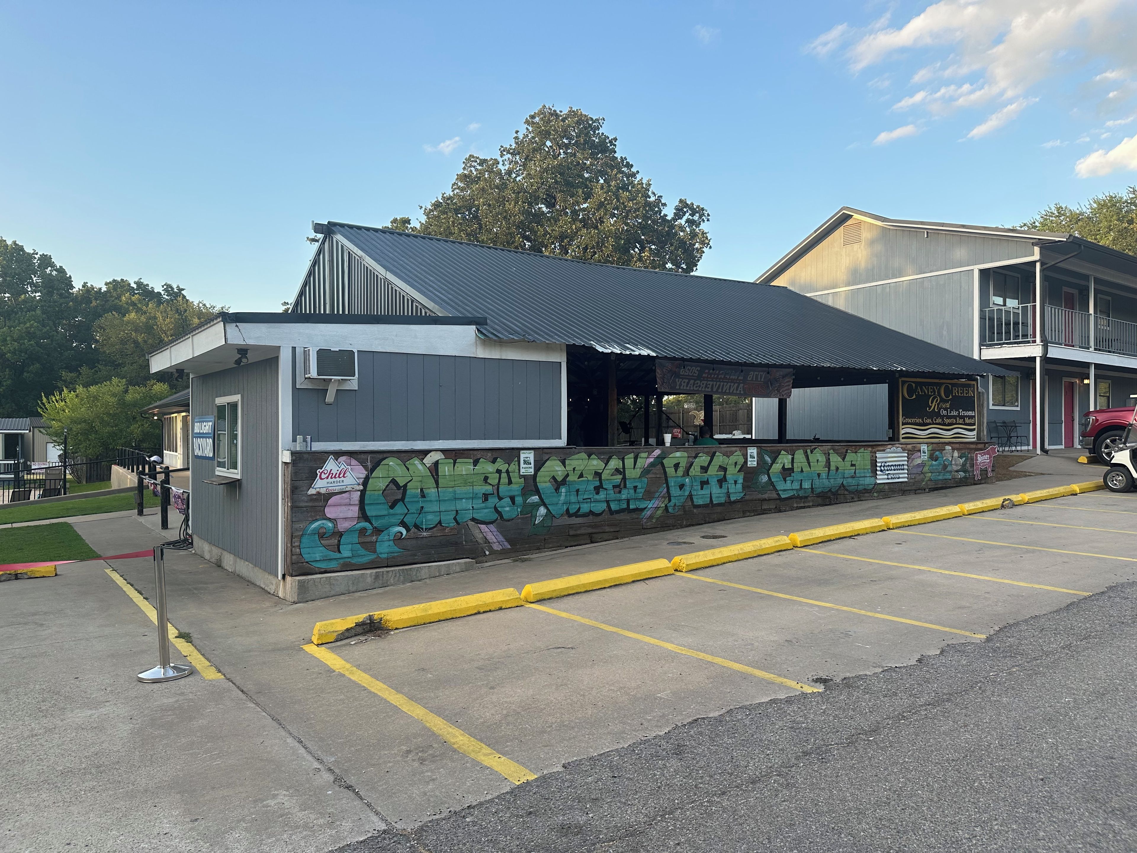 Un edificio con techo metálico y un muro lleno de grafitis coloridos.