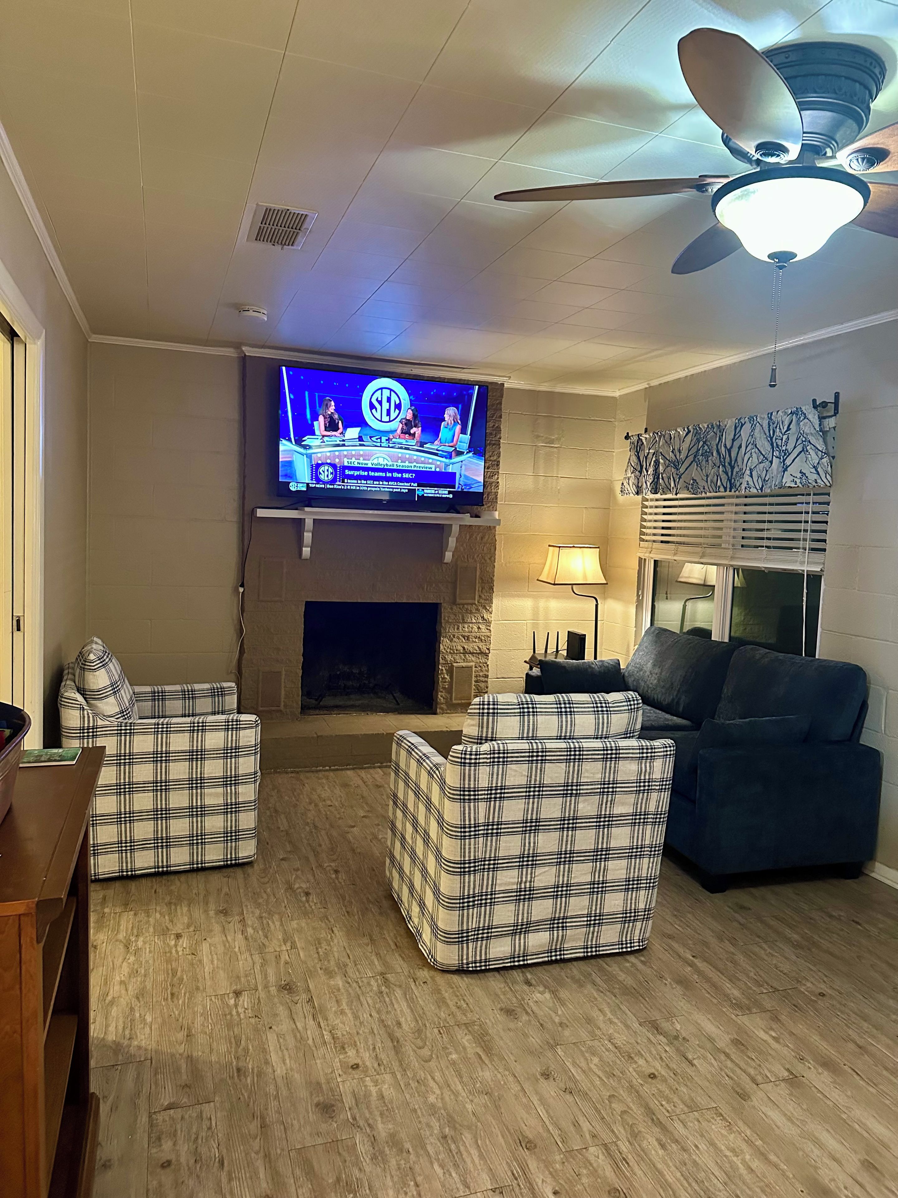 Una sala de estar con televisión, chimenea y asientos.