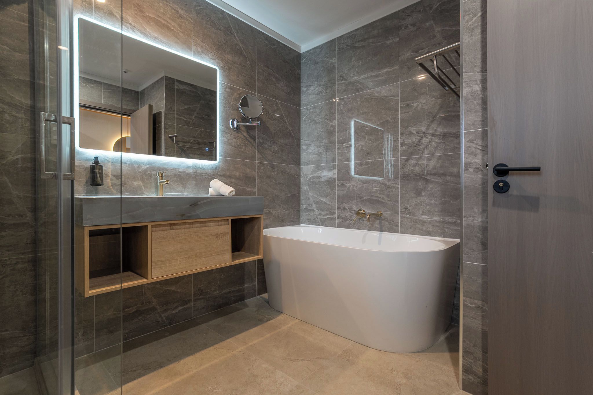 Un baño moderno con una bañera independiente, un tocador con espejo y una zona de ducha.