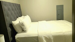 A bedroom with a bed, a ceiling fan, a door, and a framed picture on the wall. - Prime 1-bedroom apartment in Uptown Charlotte with Pool and gym (Charlotte)