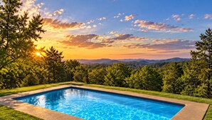A rectangular swimming pool with clear blue water, surrounded by well-maintained grass and a black metal fence. - Work & Relax Retreat, Pool, Wifi, Stocked Kitchen (Nashville)