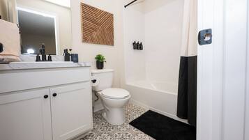 A bathroom with a toilet, sink, and bathtub.