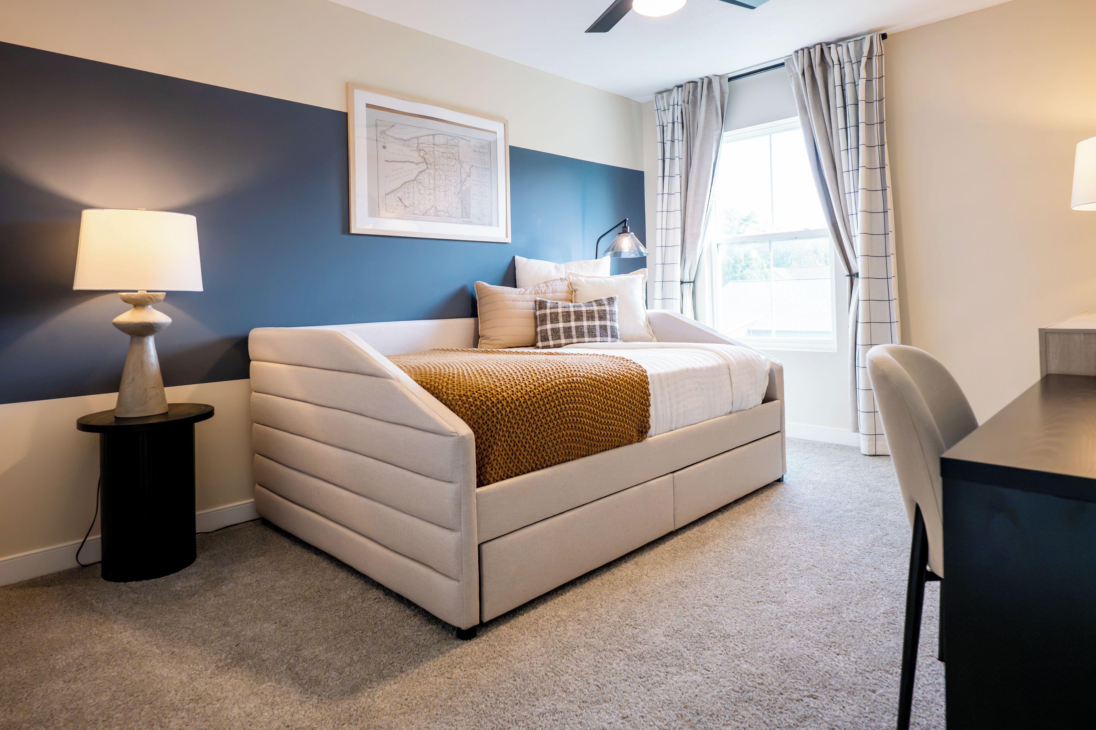 A modern bedroom with a bed, a desk, and a chair.