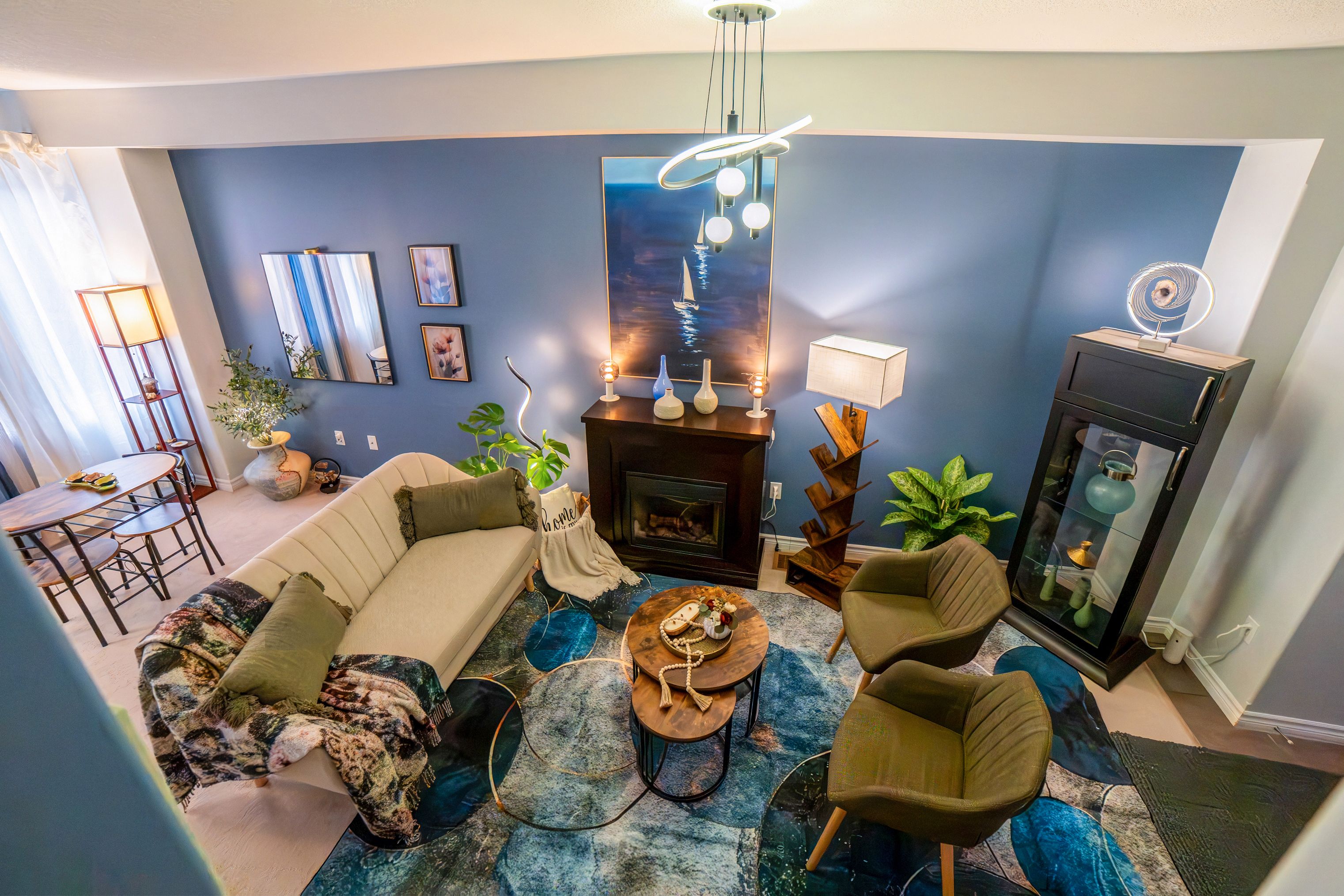 A modern living room with a sofa, armchairs, a coffee table, and a fireplace.