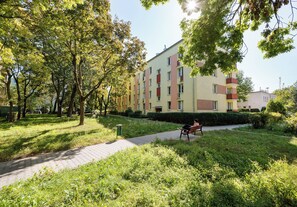 Ein Mehrfamilienhaus mit Pflasterweg und einer darauf sitzenden Person.
