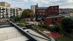 A residential area with multi-story buildings, a playground, and a parking lot. - Nyska Boutique Studio (Wrocław)