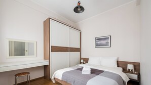 Una camera d'albergo con un letto, un comodino, una lampada e uno specchio.