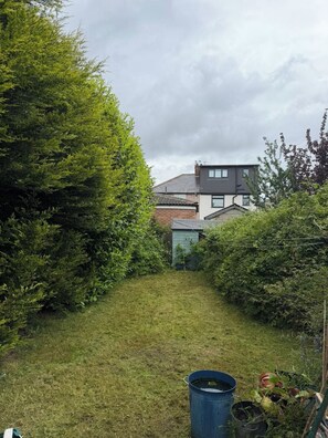 Ein Wohnhaus mit Rasenfläche, Gartenhaus und Dach