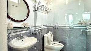 Ein modernes Badezimmer mit einem großen Spiegel, zwei Waschbecken, einer Toilette und einer Dusche.