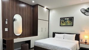 Ein Schlafzimmer mit Bett, Kleiderschrank, Spiegel und einem Bild an der Wand.