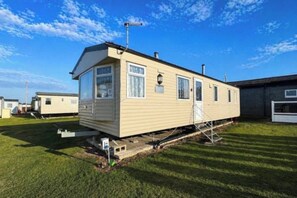 A single-story mobile home with a front porch and a small attached garage.