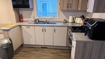 A compact kitchen with a microwave, toaster, and sink.