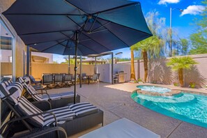 A poolside area with lounge chairs and a covered seating area. - Pool & Spa • Game Room • King Beds • 20 Guests Max (Las Vegas)