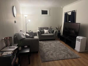 A living room with a sofa, a television, a coffee table, and a small window. - Bennett Burrow! Newly Renovated home 8 Blocks from Spokane Arena/Riverfront Park (Spokane)