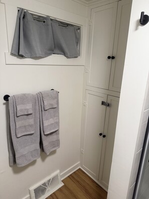 A bathroom with a white door, a towel rack with two towels, a vent, and a window with a curtain. - Bennett Burrow! Newly Renovated home 8 Blocks from Spokane Arena/Riverfront Park (Spokane)