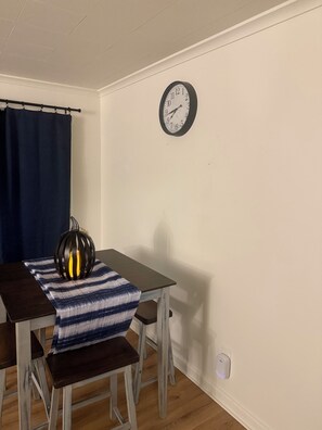 A dining area with a table, chairs, a clock, and a decorative lamp. - Bennett Burrow! Newly Renovated home 8 Blocks from Spokane Arena/Riverfront Park (Spokane)