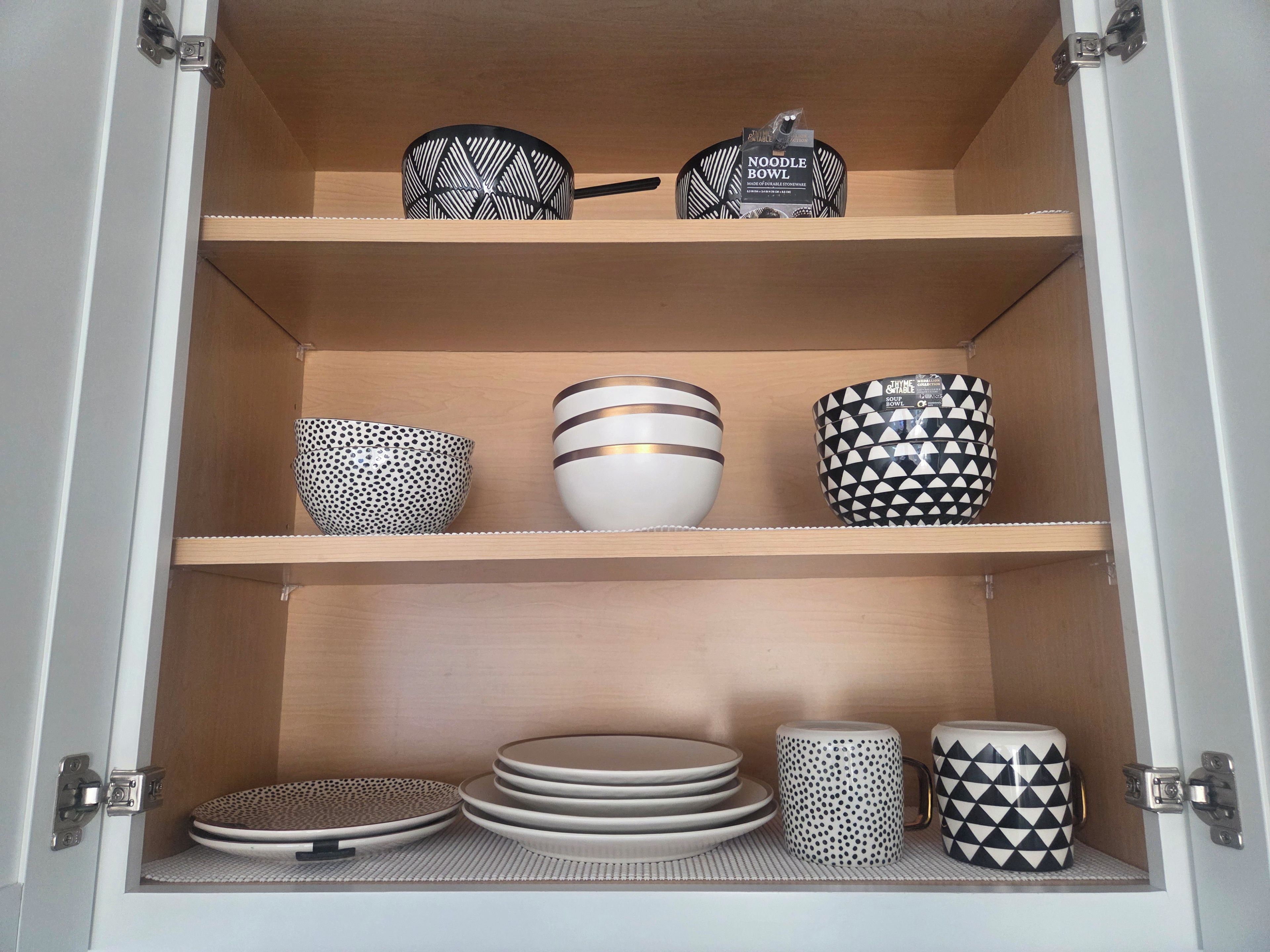 A cabinet with shelves containing various kitchenware items.