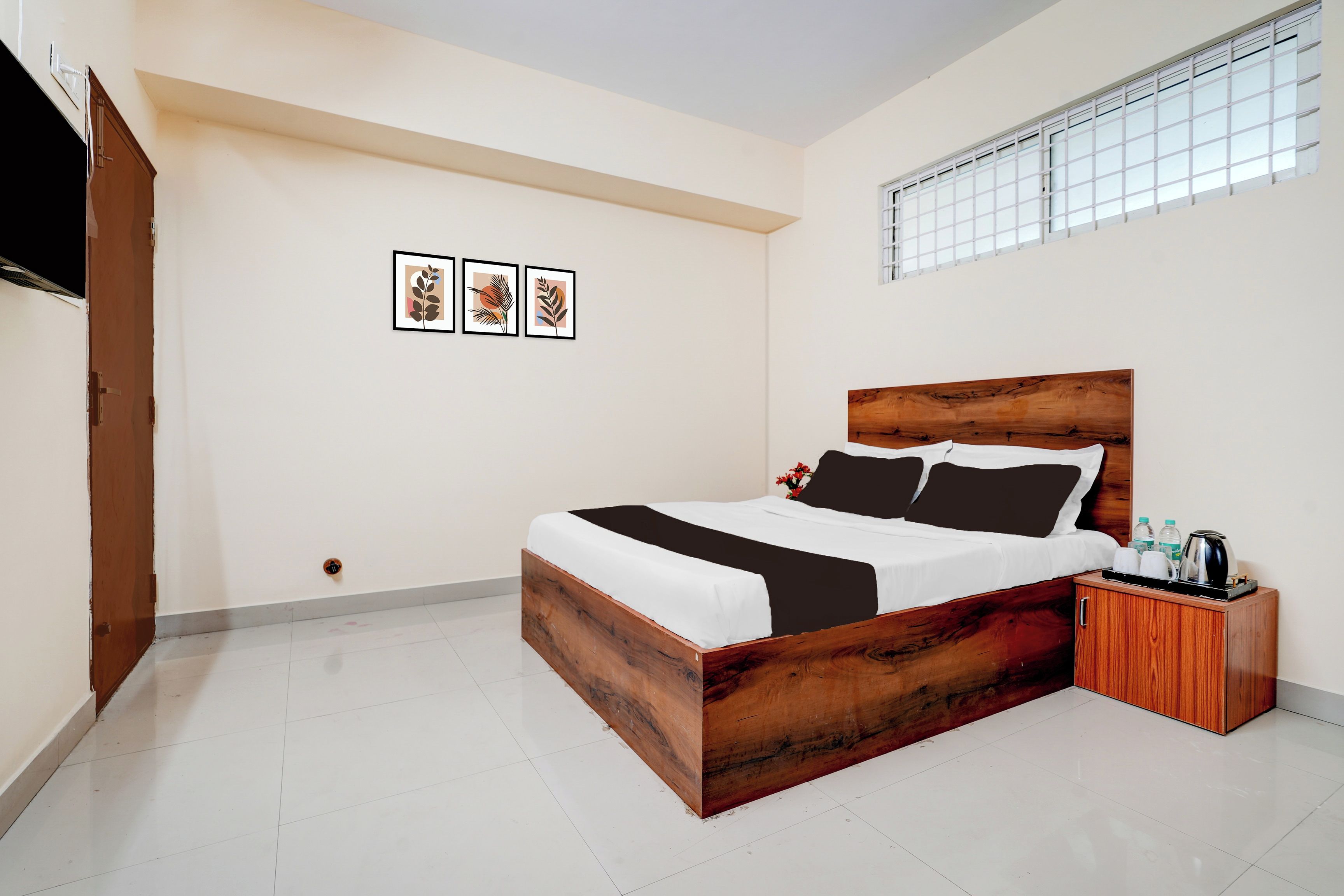 Un dormitorio con cama de madera, paredes blancas y una ventana con persianas.