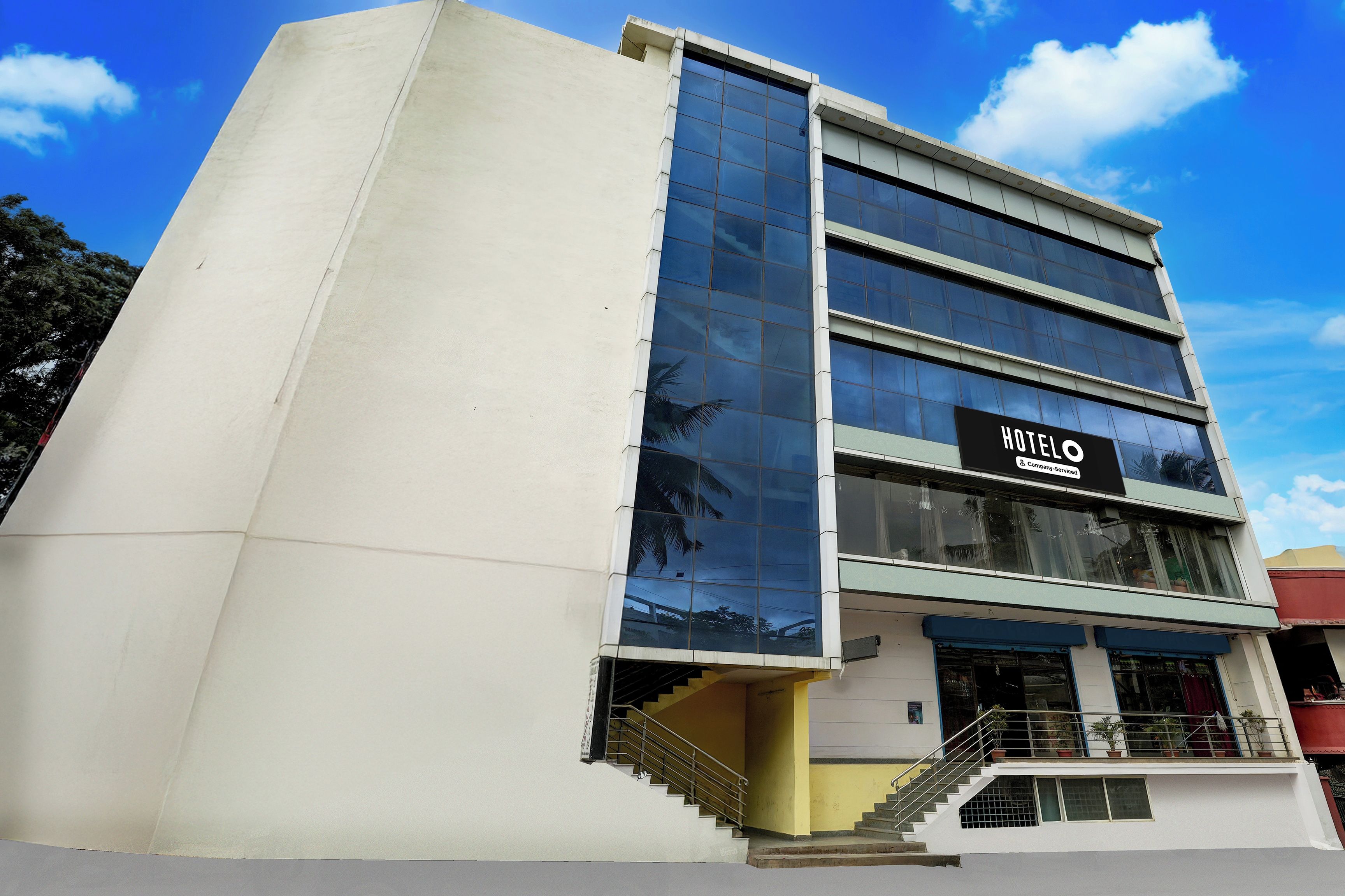 Un hotel con fachada moderna, una escalera visible y un letrero que indica que ofrece servicios para empresas.