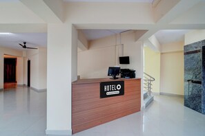 A hotel reception desk with a sign indicating it is company-serviced.